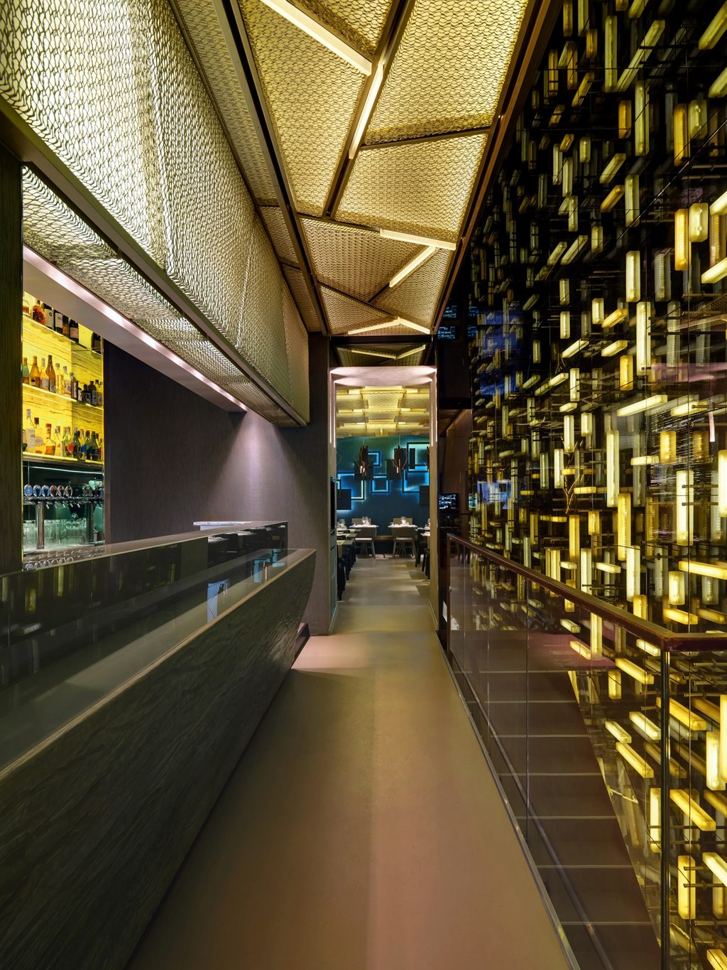 Corridoio e bar, muro di tubi luminosi moltiplicati dagli specchi