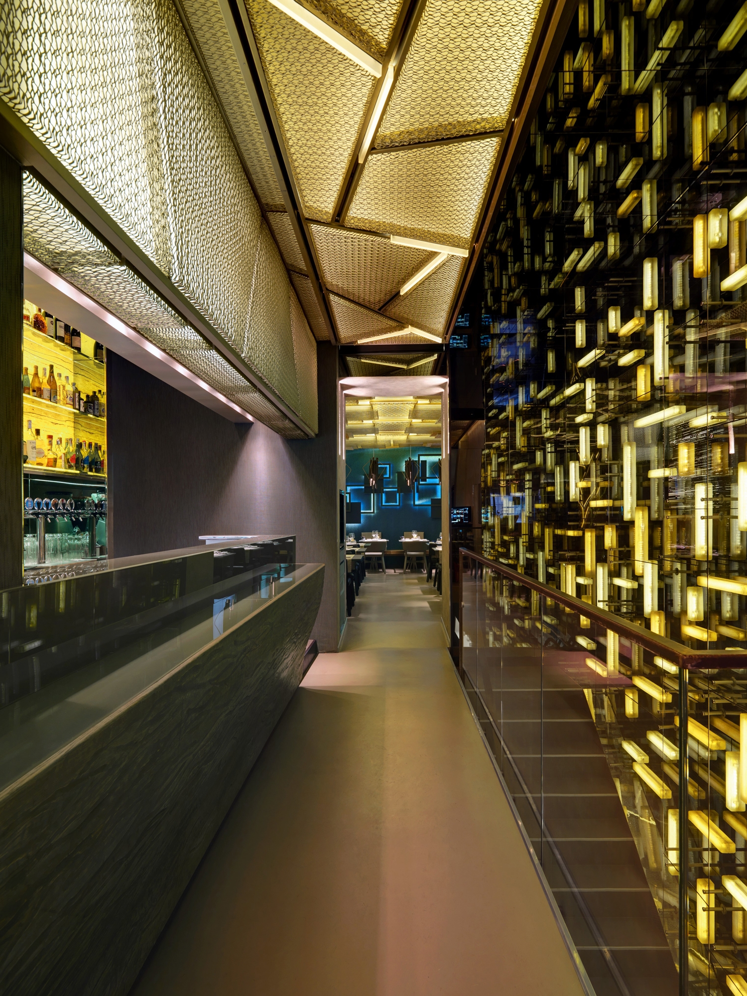 Corridoio e bar, muro di tubi luminosi moltiplicati dagli specchi